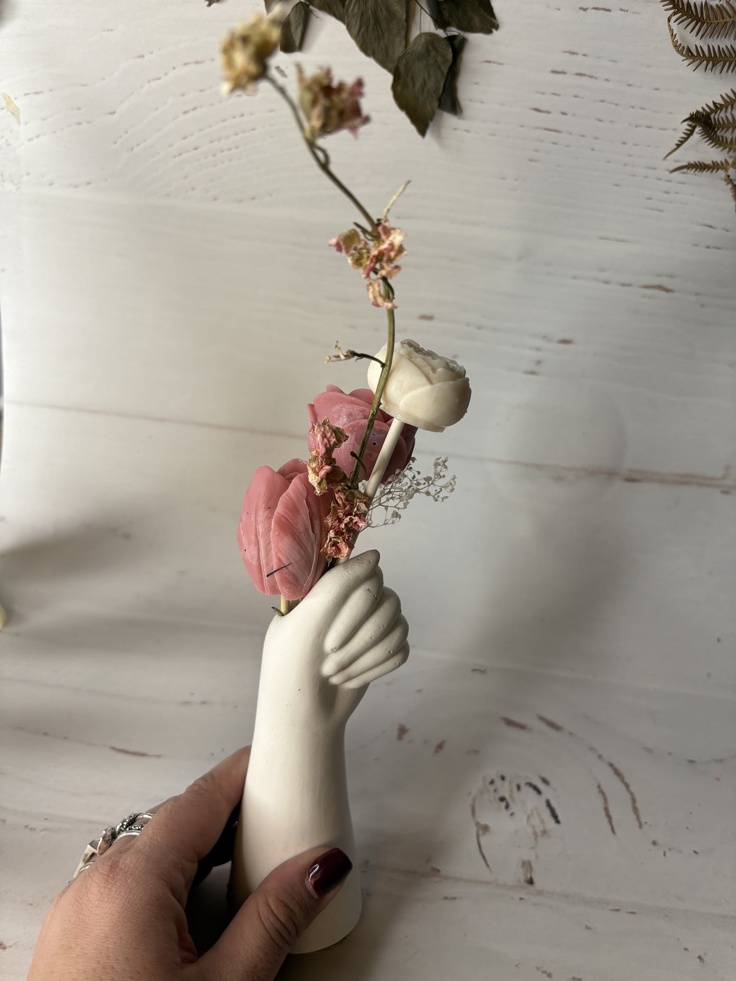 Mano fiorita-composizione vaso con cera e fiori su piattino