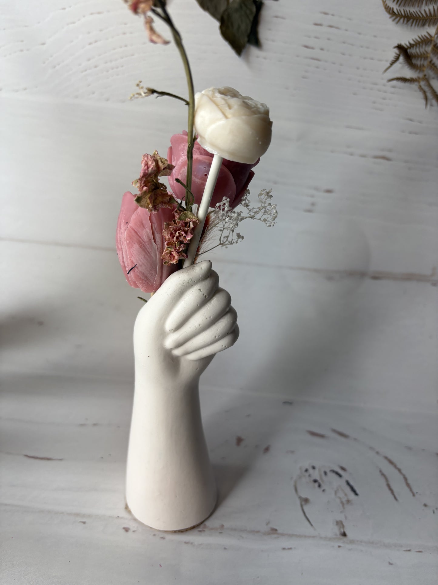 Mano fiorita-composizione vaso con cera e fiori su piattino