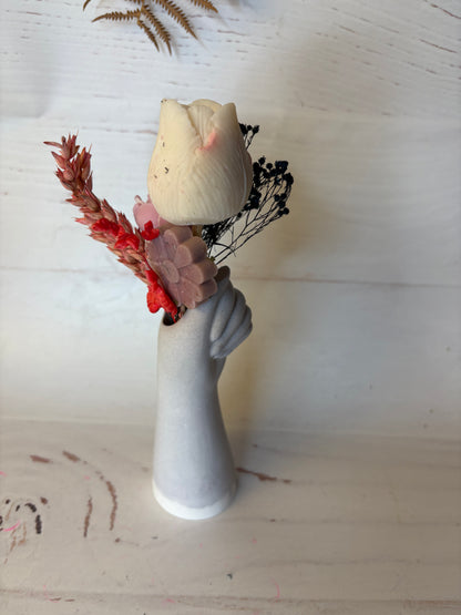 Mano fiorita-composizione vaso con cera e fiori su piattino
